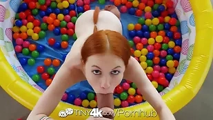 Redhead vixen Dolly Little enjoys some playful fun in a ball pit before engaging in intense and passionate sex